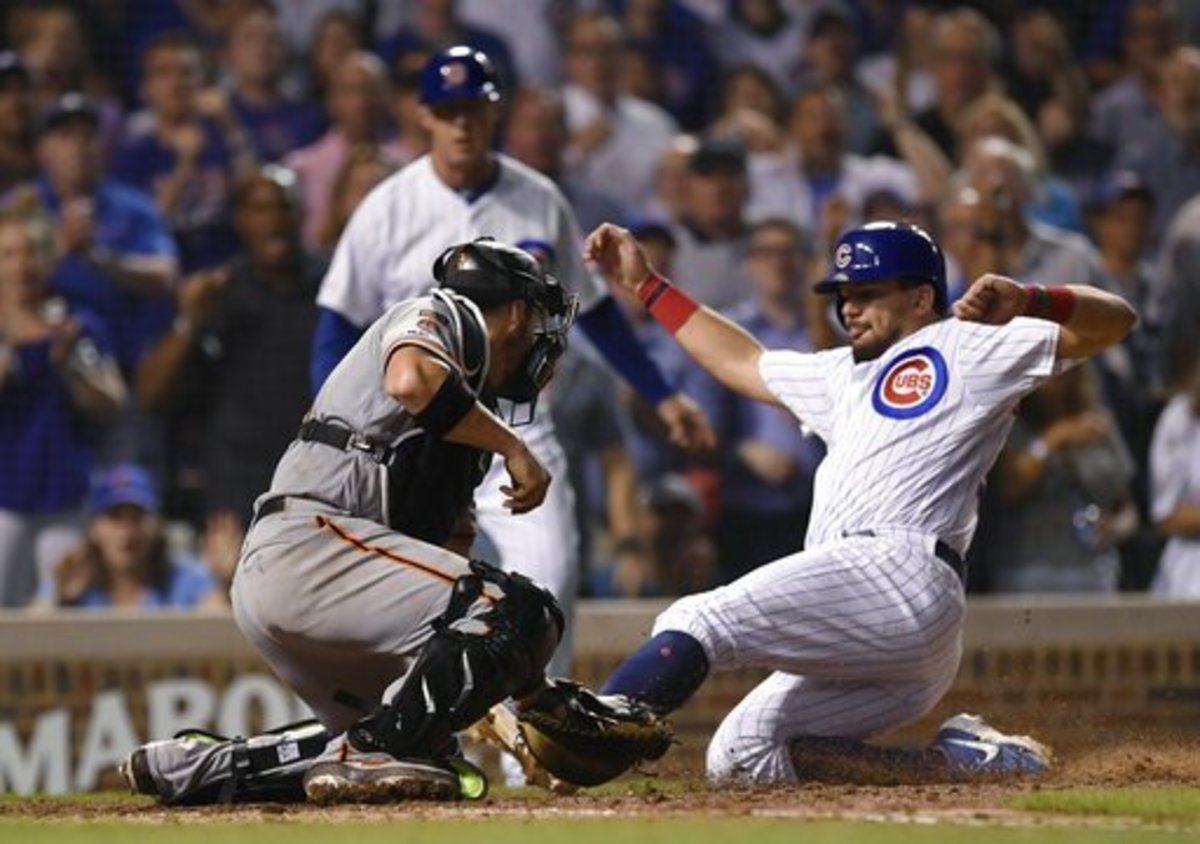 Chicago Cubs' Kyle Schwarber right, is tagged out at home plate by San Francisco Giants catcher Stephen Vogt during the eighth inning of a baseball game Wednesday, Aug 21, 2019, in Chicago. Chicago won 12-11. (AP Photo/Paul Beaty)