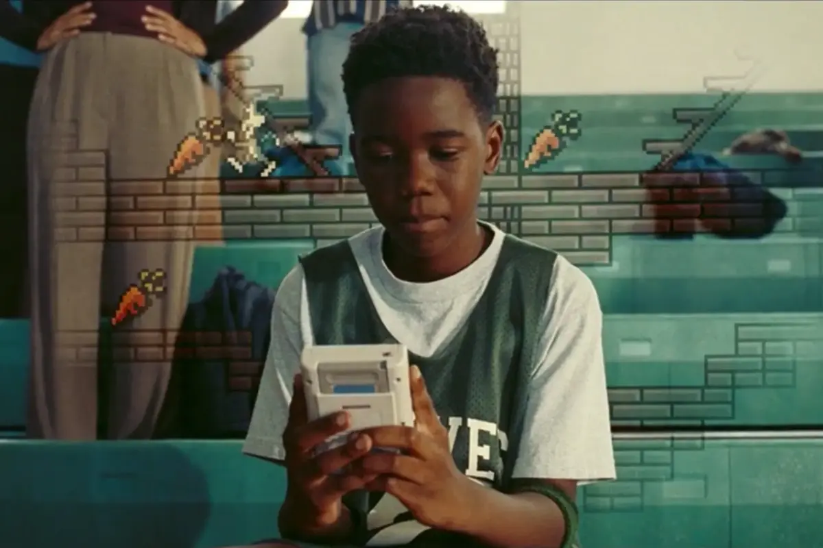 A young LeBron James (played by Stephen Kankole) gets lost in his Gameboy. Photo: Warner Bros Pictures