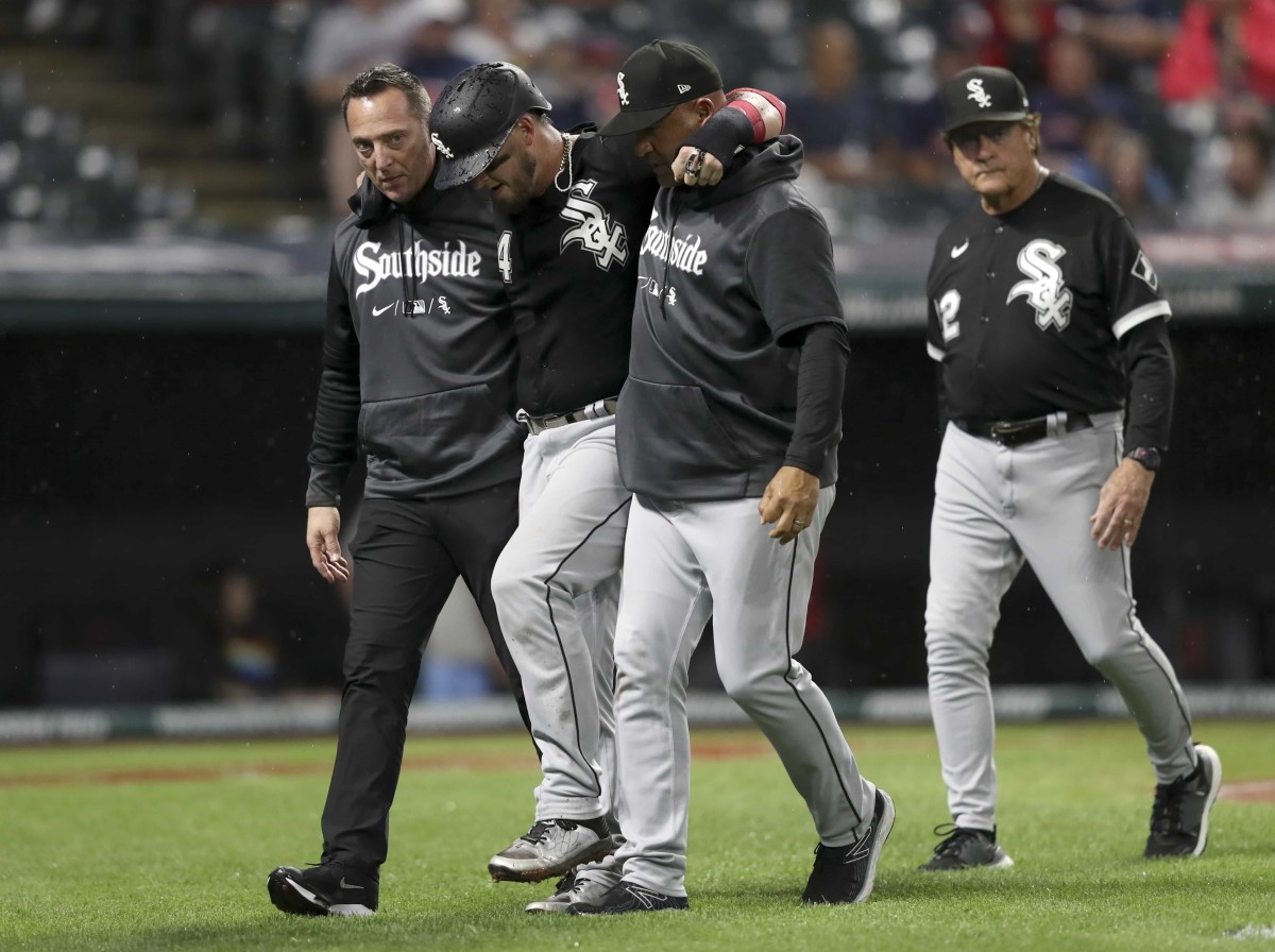 Aug 20, 2022; Cleveland, Ohio, USA; Chicago White Sox catcher Yasmani Grandal (24) leaves the field with the help of trainers and manager Tony La Russa (right) after being tagged out at home by Cleveland Guardians catcher Luke Maile (12) in the seventh inning at Progressive Field.