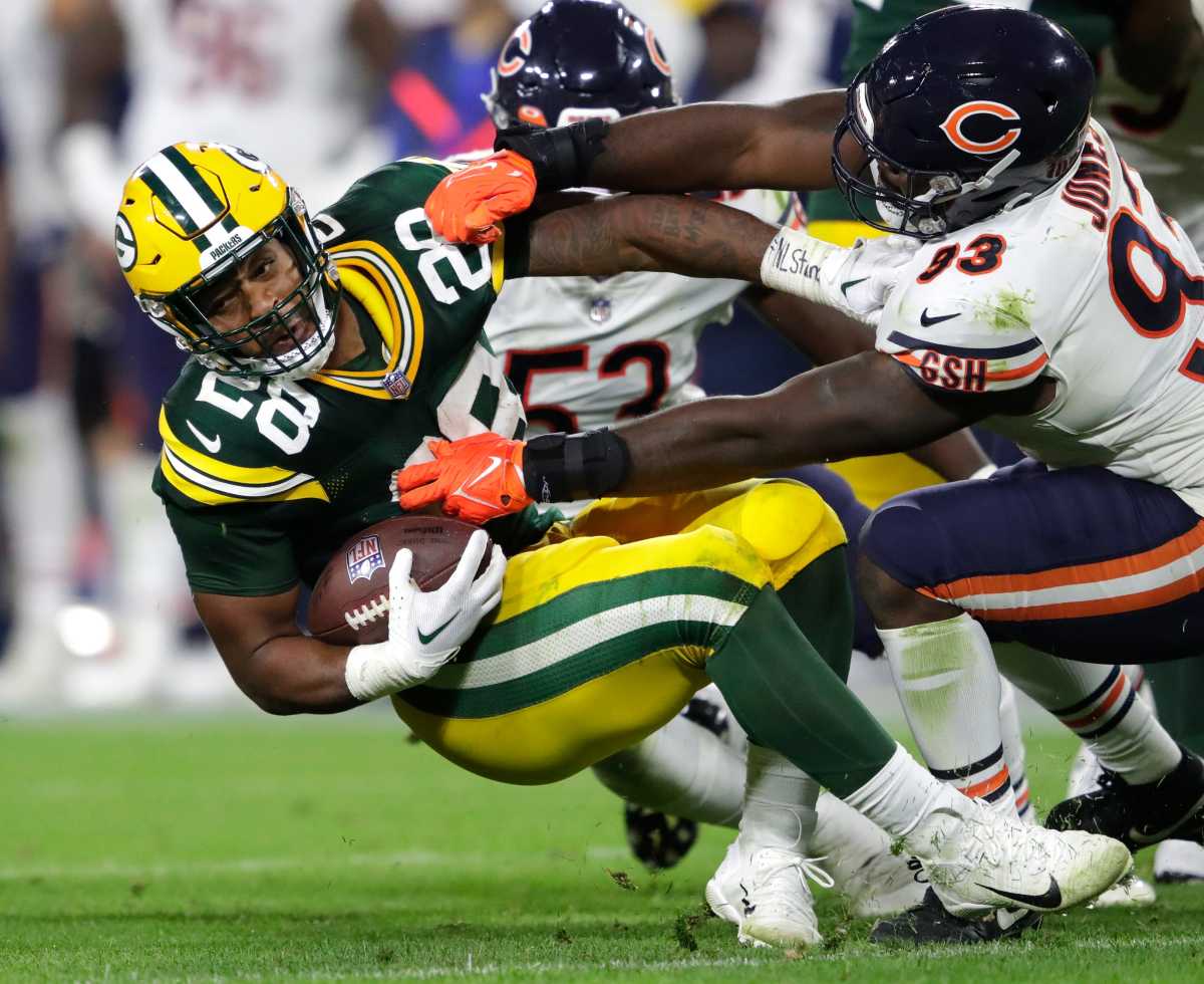 Green Bay Packers running back AJ Dillon (28) is tackled by Chicago Bears defensive tackle Justin Jones (93) during their football game Sunday, September 18, 2022, at Lambeau Field in Green Bay, Wis.