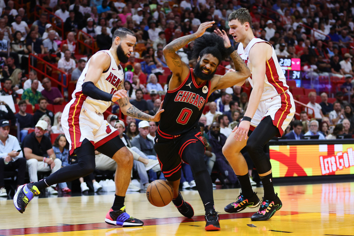 Apr 19, 2024; Miami, Florida, USA; Chicago Bulls guard Coby White (0) reacts after driving to the basket against Miami Heat forward Caleb Martin (16) and forward Nikola Jovic (5) in the second quarter during a play-in game of the 2024 NBA playoffs at Kaseya Center.