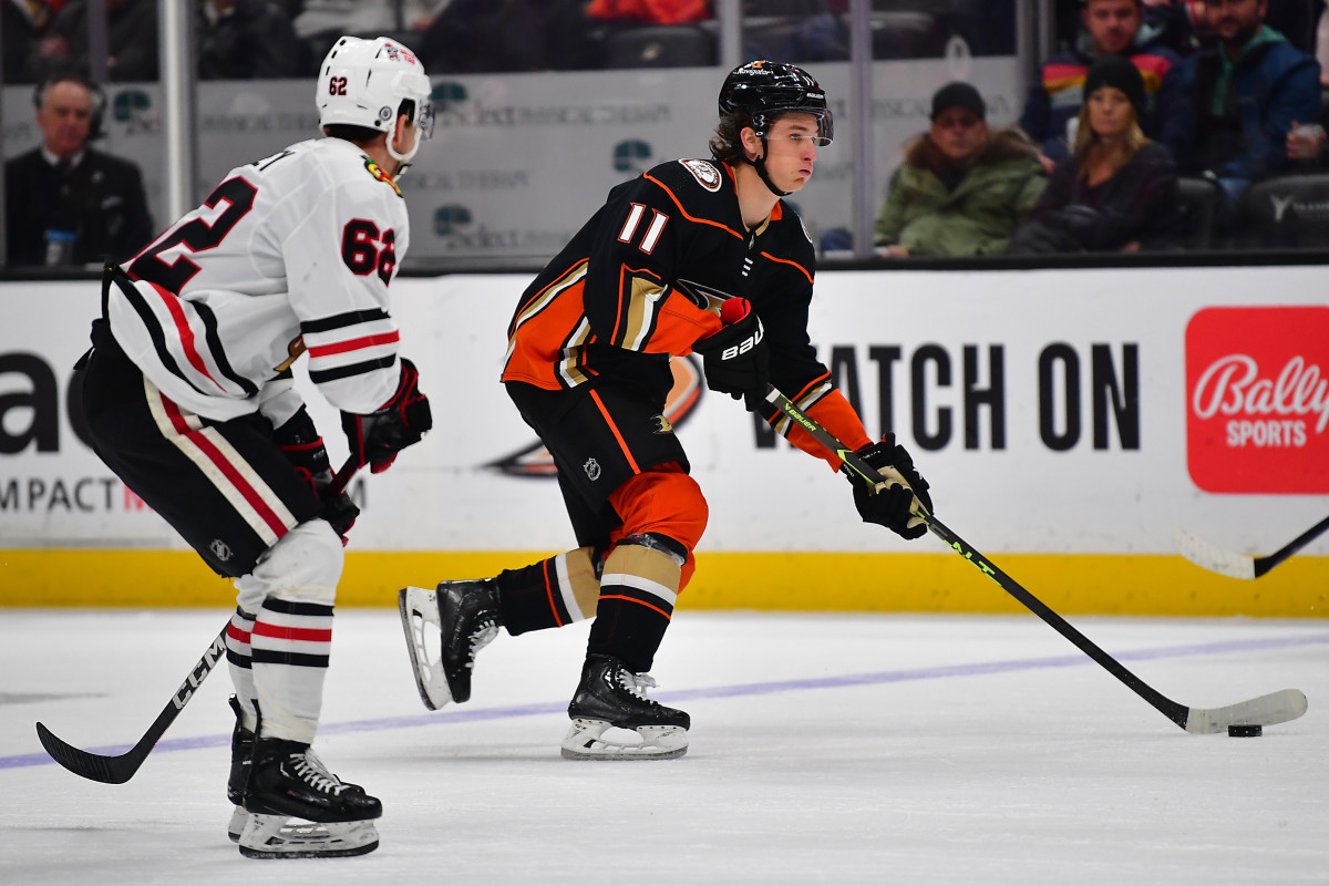 Feb 27, 2023; Anaheim, California, USA; Anaheim Ducks center Trevor Zegras (11) moves the puck ahead of Chicago Blackhawks left wing Brett Seney (62) during the second period at Honda Center.